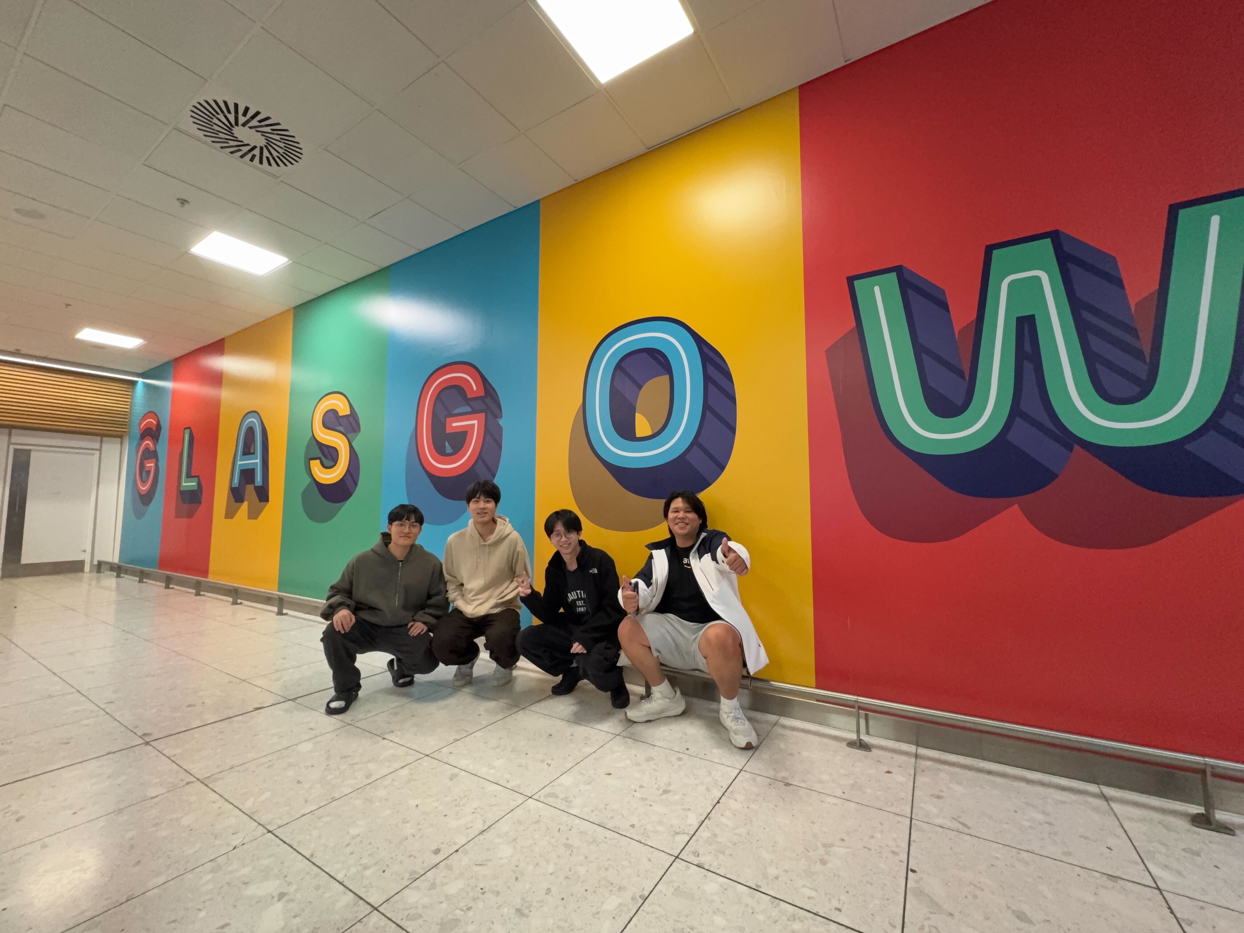 Group photo in front of the Glasgow Airport mural